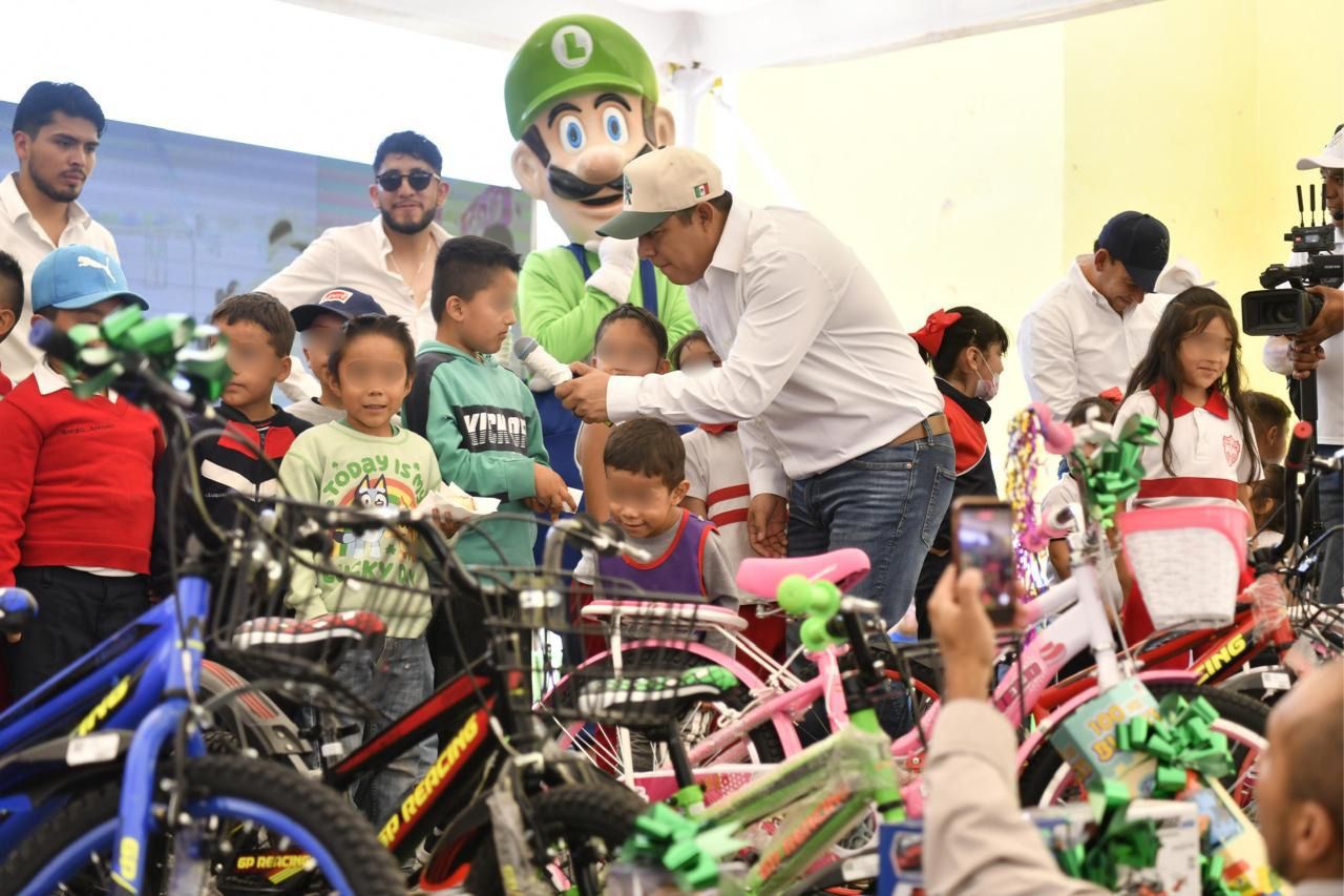 El gobernador entregó juguetes a menores y arrancó la pavimentación de calles en la comunidad de El Rosario; anunció además una nueva preparatoria para el municipio.